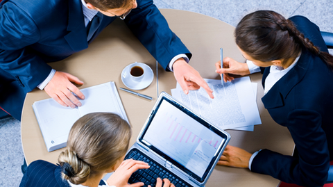 3 personnes travaillant sur ordinateur sur une table ronde 3 personnes travaillant sur ordinateur sur une table ronde