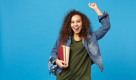 Etudiante qui réussit Etudiante main levée et large sourire
